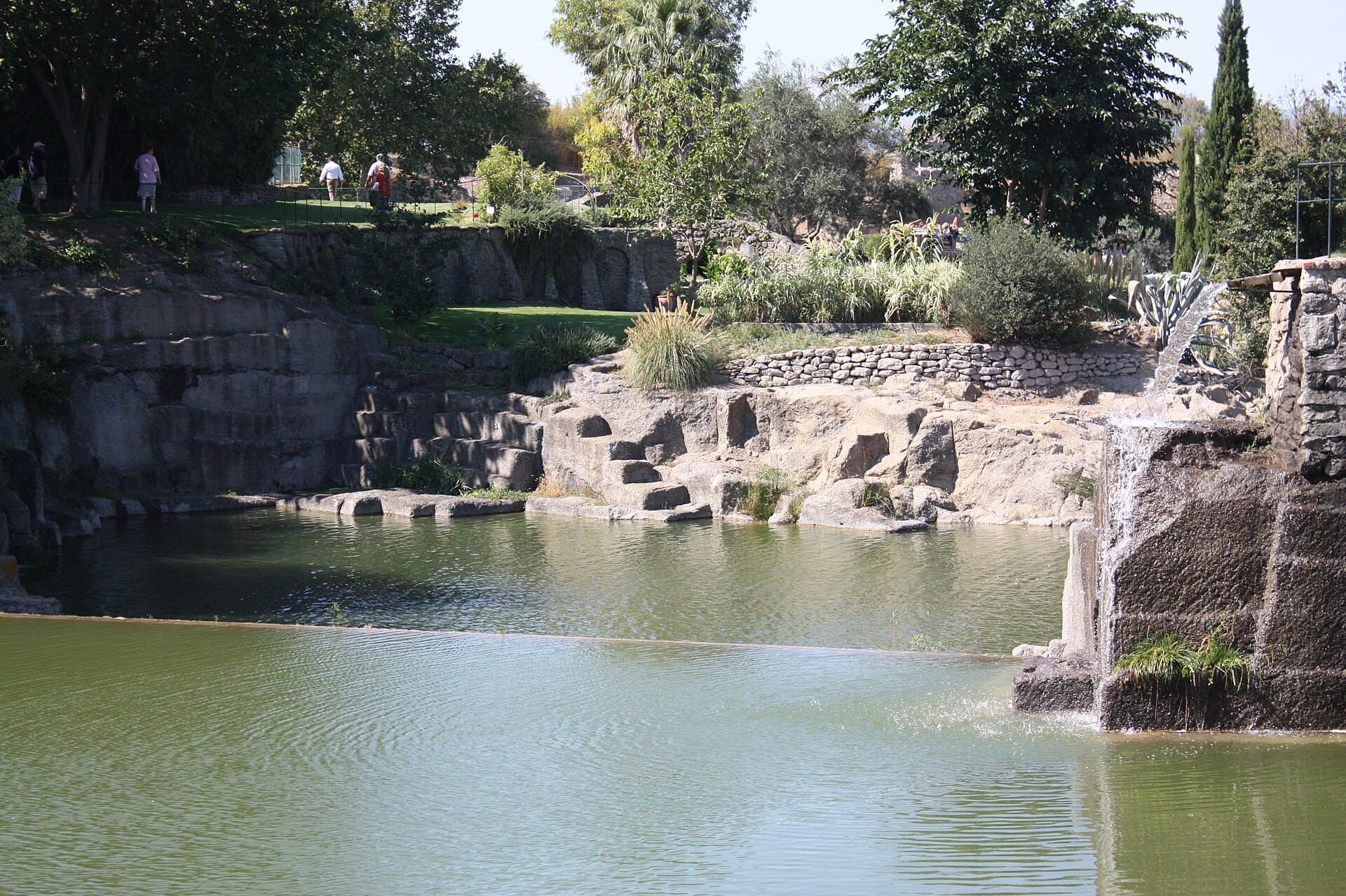 Jardin paysager aménagé avec massifs, allées et pièce d'eau